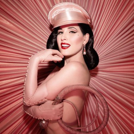 Dita Von Teese in a designer costume poses for a photoshoot.